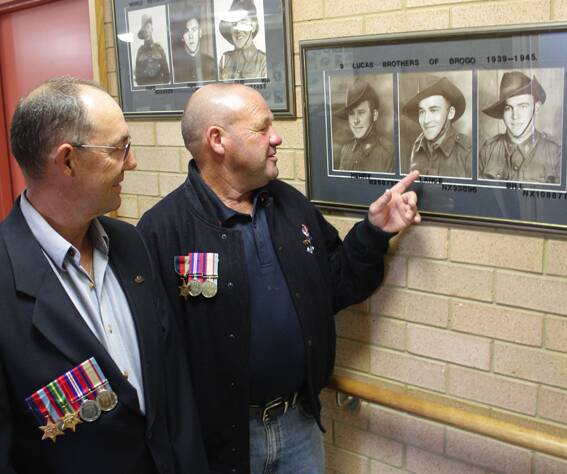 Before Anzac Day on Sunday, Geoffrey (Hedley) and Henry (H) Lucas, proudly wearing their father’s medals, admire a  photo of their dad, Lance.