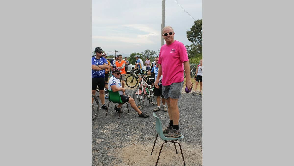 Event organiser Richard Gallimore stands on a chair before delivering his pre-ride safety induction ahead of the Tathra Wharf to Waves bike ride on Saturday.