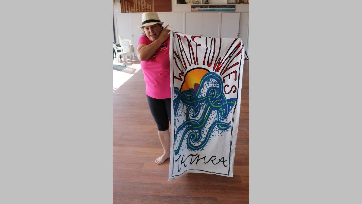 Linda Badewitz-Dodd shows off the specially designed Wharf to Waves towels, which will be handed to the winner in each swimming race.