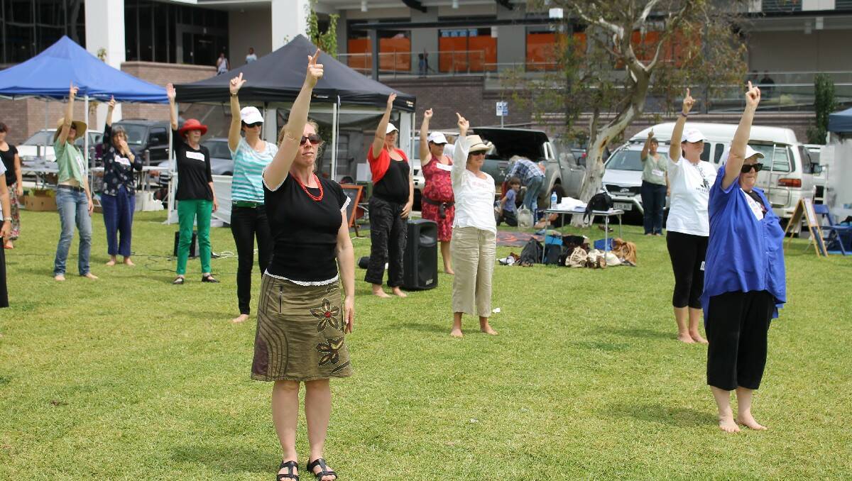 “One Billion Raising for Justice” flash mob participants remind Bega residents about the campaign's aim, signifying number one with their finger.