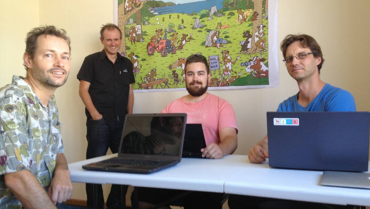 Coordinator of COWS (co-working space) Near the Coast Liam O’Duibhir (standing) checks on the progress of mobile app developers (from left) Harry Binnendijk of Wandella, University of Wollongong Bega student Adam Buckley and Carsten Ecklemann of Bega.