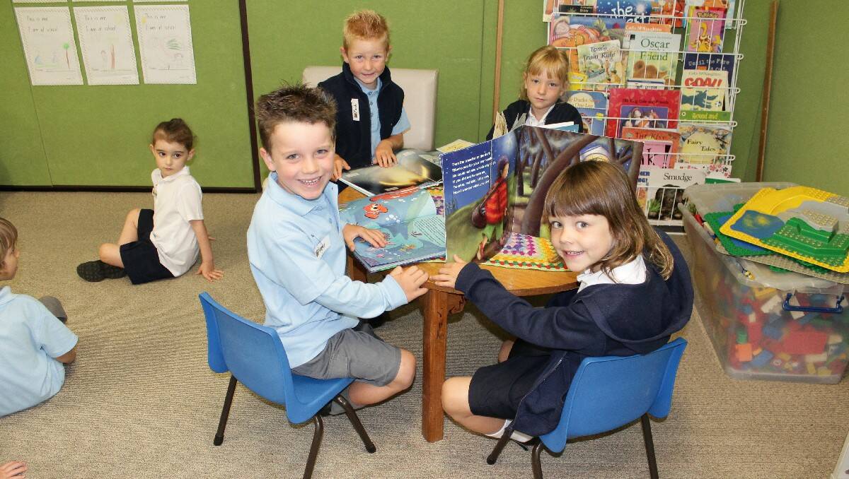 Happy to be reading are Bermagui Public School Kindies (from left) Angus, Zach, Neave and Claire.