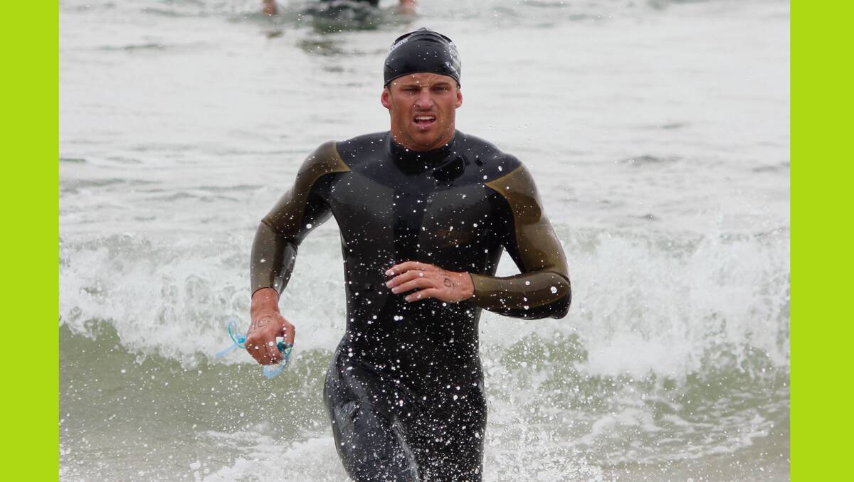 • Tathra’s Shayne Rettke emerges from the water to win in the 20-29 men’s age group during the Wharf to Waves on Sunday. Rettke also came third in the Splash for Cash. 