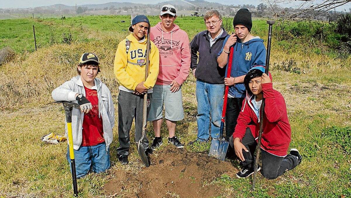 • Preparing to plant a tree along Tarraganda Rd are (from left) Bega High School Permaculture students Matt Worthington and Desmond Campbell, group aide Matt Parbery, Bega Lions Club president Robert Jeffery and students Wayne Rootsey and Joseph Pabon.
