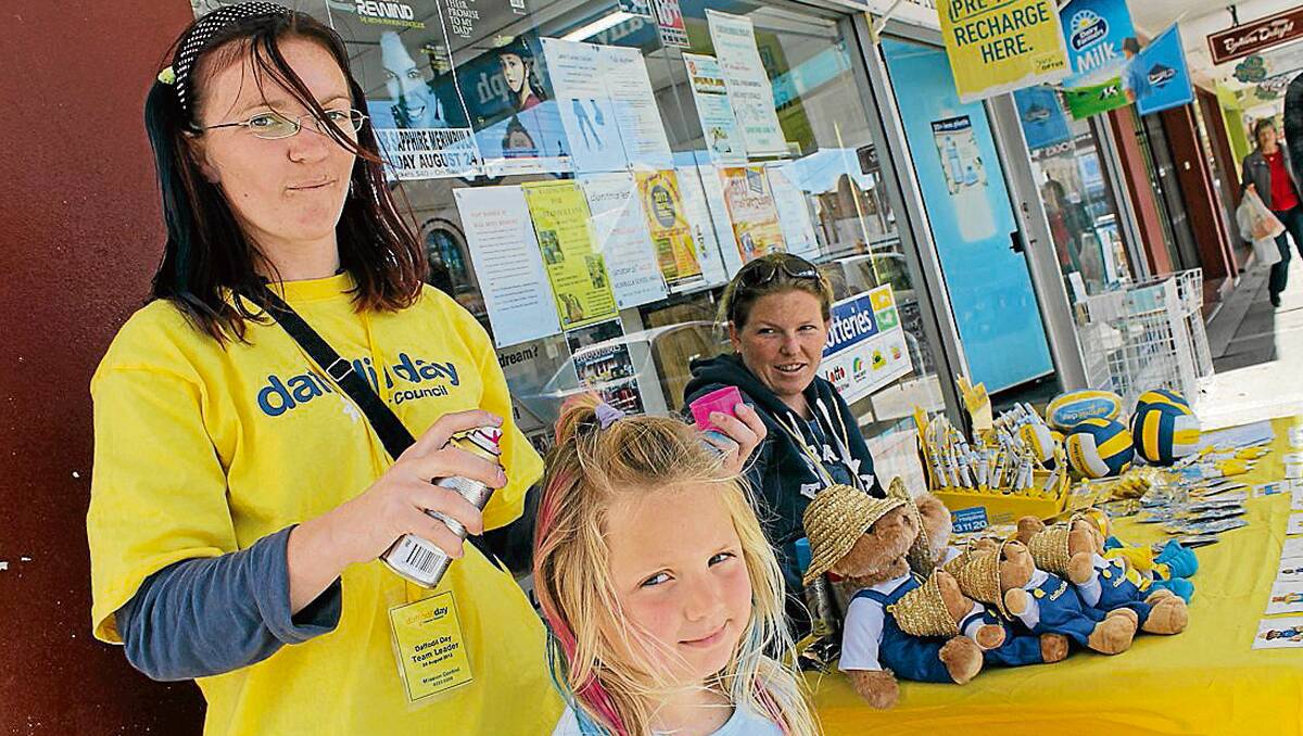 • Sammy Fuge sprays Amali Osmond’s hair as part of the Daffodil Day fundraising event in Bega last week. 