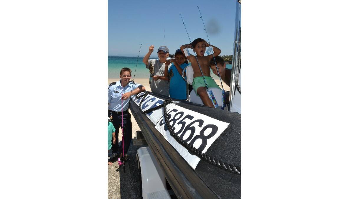 Daisy Pipe, AFP first constable Ben Pipe, Tim Askew and Keyala Brown from Jervis Bay, Tristian Archibald from Kempsie and Ben Askew from Jervis Bay check out the awesome police rescue boat at the Australian Federal Police and Wreck Bay Indigenous Community “Off the Hook” Kids Fishing Fun Day at Summercloud Bay on Wednesday.